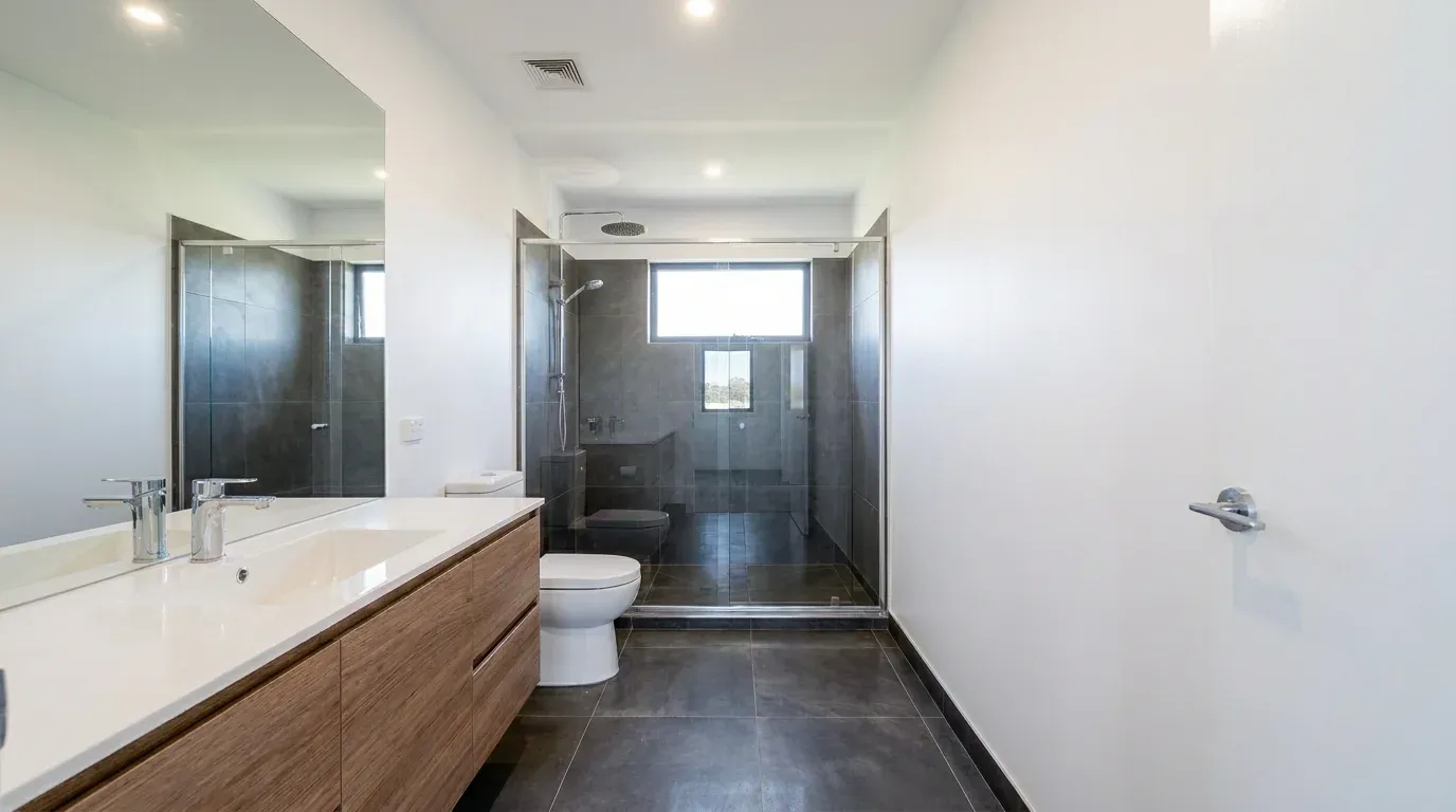 Baño con vanity de madera en una casa modelo de Masías at the Hills